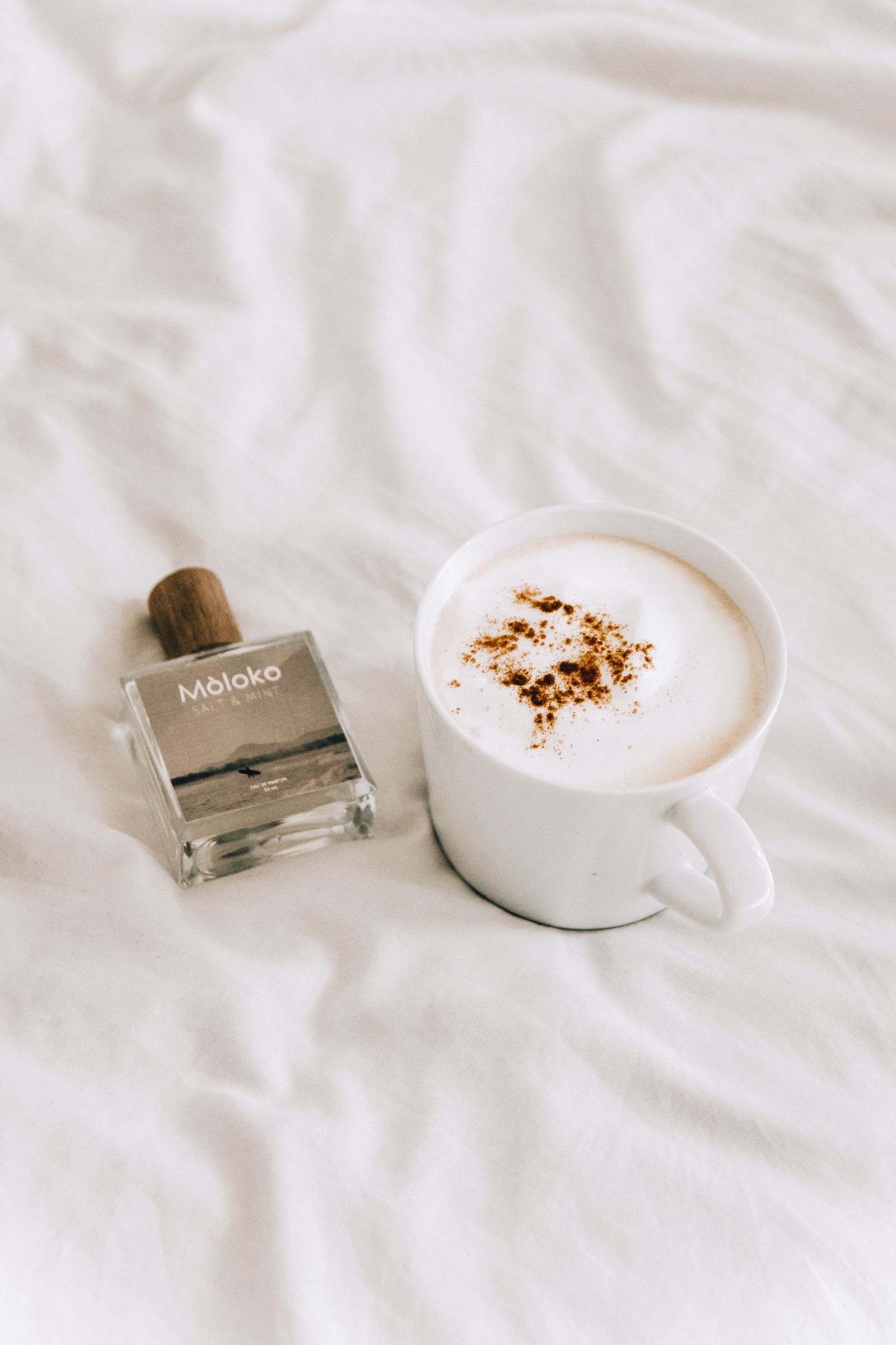 Perfume bottle beside a coffee cup, illustrating gourmand scent inspiration