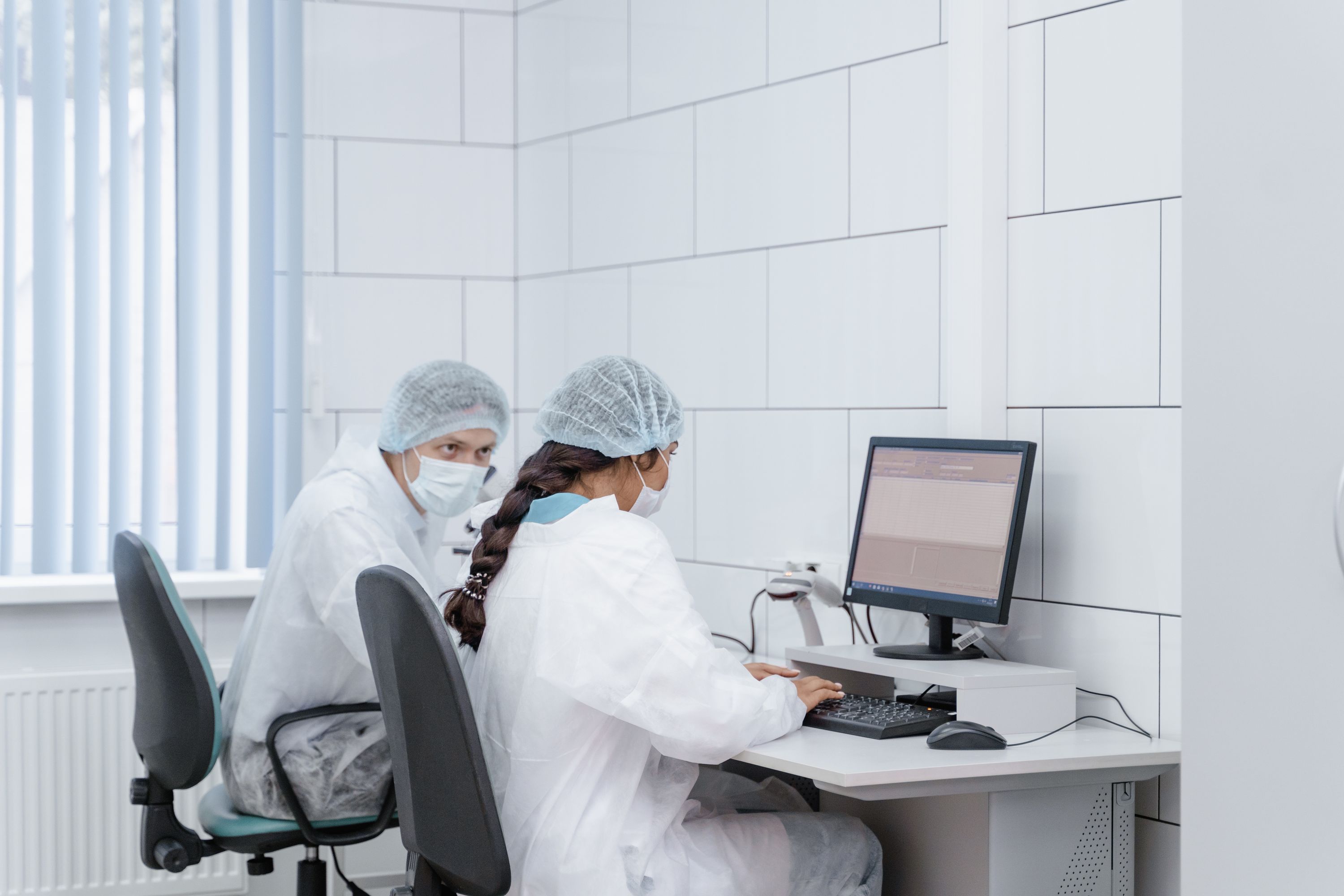 Illustrative stock photograph: white-coated professionals reviewing information in a clean laboratory